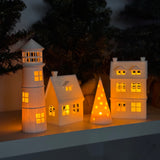 Set of decorative houses with lights on a dark background